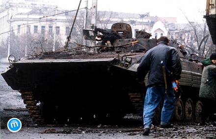 Egy csecsen harcos fut el egy kiégett orosz BMP-2-es lövészpáncélos mellett a Groznijért folyó csata során.